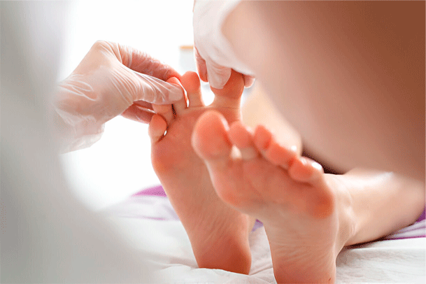 podologo examinando uñas de los pies con hongos